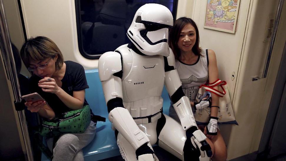 Seorang storm trooper sedang duduk bersama para penumpang lainnya.